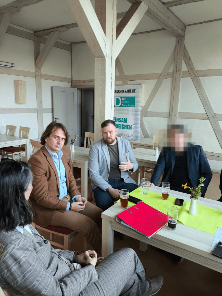 Diskussion im Fachwerkhaus mit WLD-Banner